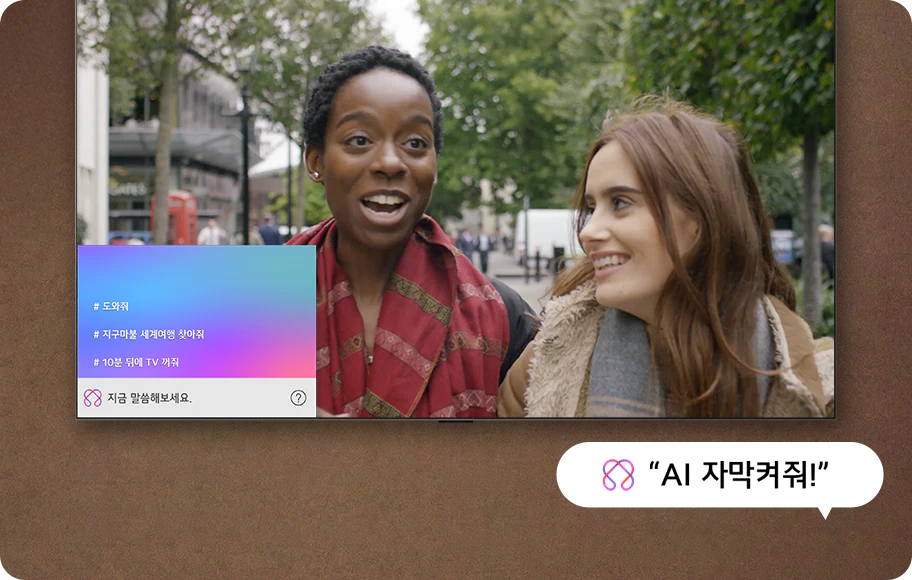 다른 언어로 된 콘텐츠가 있는 벽걸이형 LG TV. LG AI 자막 UI가 나타나 콘텐츠를 번역하고 TV에 자막을 실시간으로 표시하는 방식을 보여줍니다. 좌측 인터페이스에는 [도와줘, 지구마불 세계여행 찾아줘, 10분 뒤에 TV 꺼줘, 지금 말씀해보세요.]라고 출력하고 있으며 [AI 자막 켜줘]라고 적힌 말풍선을 통해 사용자가 TV의 기능 사용하는 것을 알 수 있습니다.